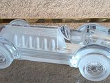 a silver model of a car on display on a glass table