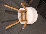 a white chair with wooden legs on a carpeted floor