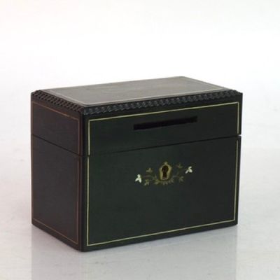 une petite boîte noire ornée d'un emblème doré