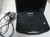 un ordinateur portable posé sur une table avec un chargeur