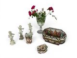a vase with flowers and figurines on a table