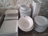de nombreuses assiettes et bols blancs sur la table