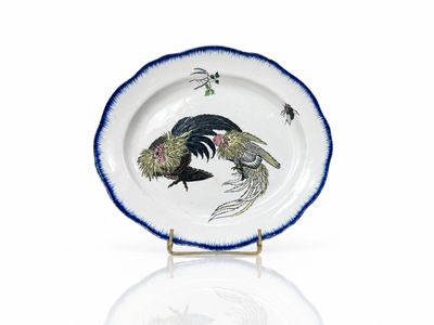 une assiette bleue et blanche sur laquelle est représenté un coq