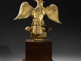 an image of a gold eagle statue on a wooden base