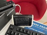 a keyboard and a mouse on a desk with a red chair in the background