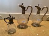 three glass vases sitting on a table next to each other
