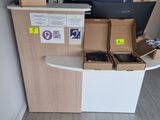 un petit bureau sur lequel se trouvent un ordinateur portable et plusieurs boîtes