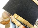 a black hat with a gold band on top of it