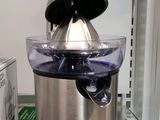une photo d'un presse-agrumes en acier inoxydable dans un réfrigérateur