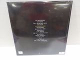 the back cover of a black album with a picture of a man in a red shirt