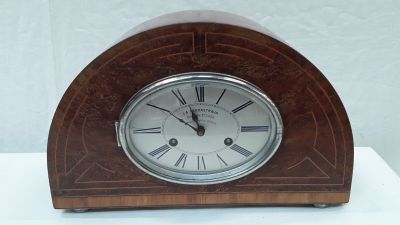 a small wooden clock with roman numerals on it
