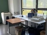 un bureau sur lequel se trouve une imprimante, dans une pièce dotée d'une grande fenêtre