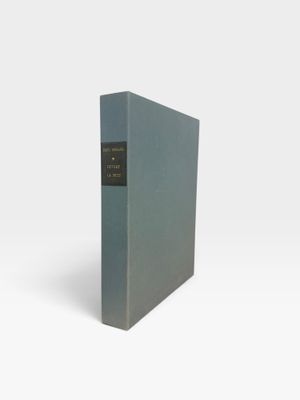 un livre bleu à la couverture noire posé sur une surface blanche