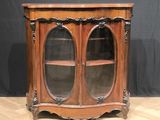 an antique wooden cabinet with glass doors on a wooden floor