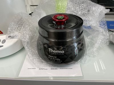 a black container with a red lid sitting on a desk
