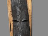 an image of a wooden mask hanging on a wall