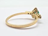 a close up of a gold ring with an emerald stone in the center