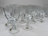 several empty wine glasses lined up on a white table