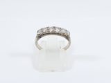a close up of a diamond ring on a white surface