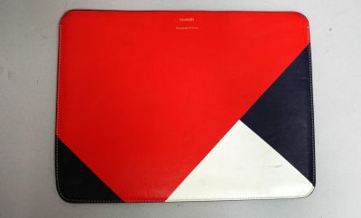 une housse d'ordinateur portable rouge, blanche et bleue posée sur une table