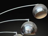 three chromed metal lamps on a black background with a black background