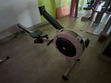 un rameur rose et noir dans une salle de sport