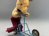 un ours en peluche assis sur un petit chariot