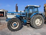 a blue tractor that is parked in a parking lot