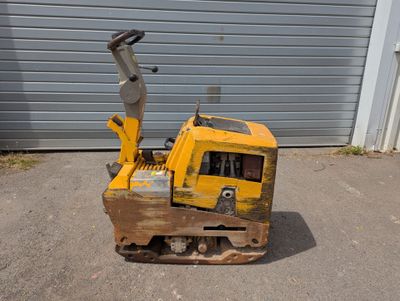 un bulldozer jaune garé devant un garage