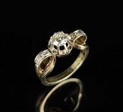 gros plan d'une bague en or et diamants sur une surface noire