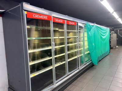 une photo d'un magasin vide recouvert d'une bâche verte