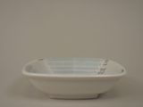 a white bowl with blue stripes on it on a table