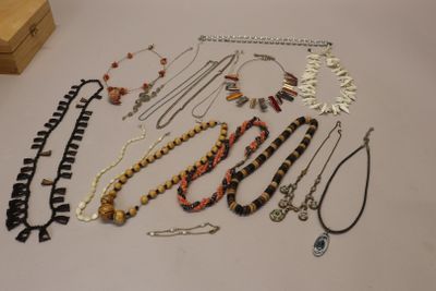 many necklaces and bracelets laid out on a table