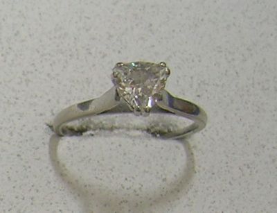 une image d'une bague en diamant sur une surface blanche