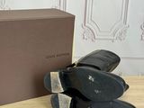 black leather slippers with a box on a table next to them