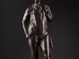 une statue en bronze représentant un homme debout sur un rocher
