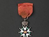 a close up of a medal on a black surface with a red ribbon