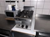 a stove and a microwave in a kitchen with stainless steel counter tops