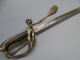 a silver sword with a wooden handle on a white surface