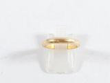 gros plan d'une bague en or sur une surface blanche