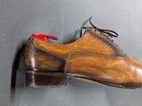 a shoe hanging on a wall with a red tie
