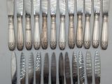 a lot of silverware on a table with a knife and fork