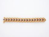 un bracelet en or avec des pierres multicolores sur fond blanc