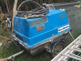 a blue machine that is sitting in the grass