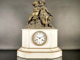 une statue représentant un garçon et une horloge posée sur un socle