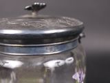 a glass jar with a lid that has flowers in it