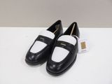 a pair of black and white shoes on a white table