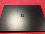 une surface noire fixée sur un mur rouge, sur laquelle figure le logo Microsoft
