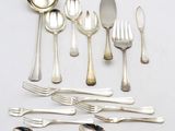 a lot of silver spoons and spoons on the table