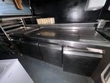 une cuisine équipée d'appareils électroménagers en inox et d'un évier